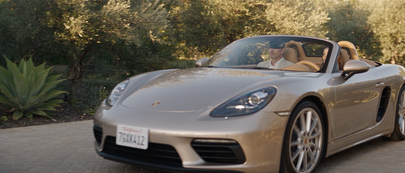 A guest arriving by car at a gated community in the evening sun